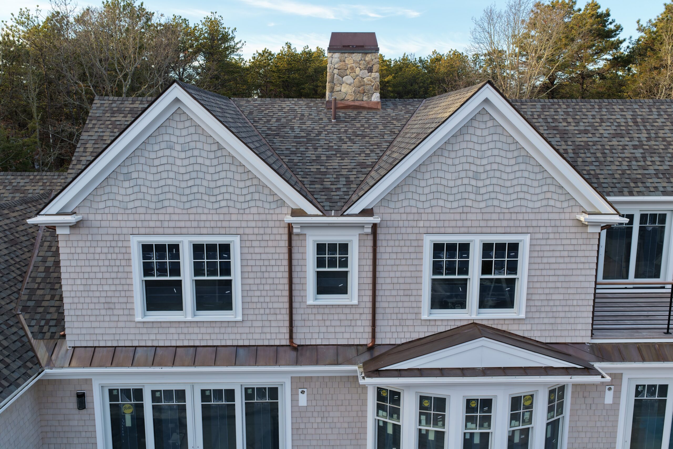 Natural white cedar siding with woven corners and stone chimney detail