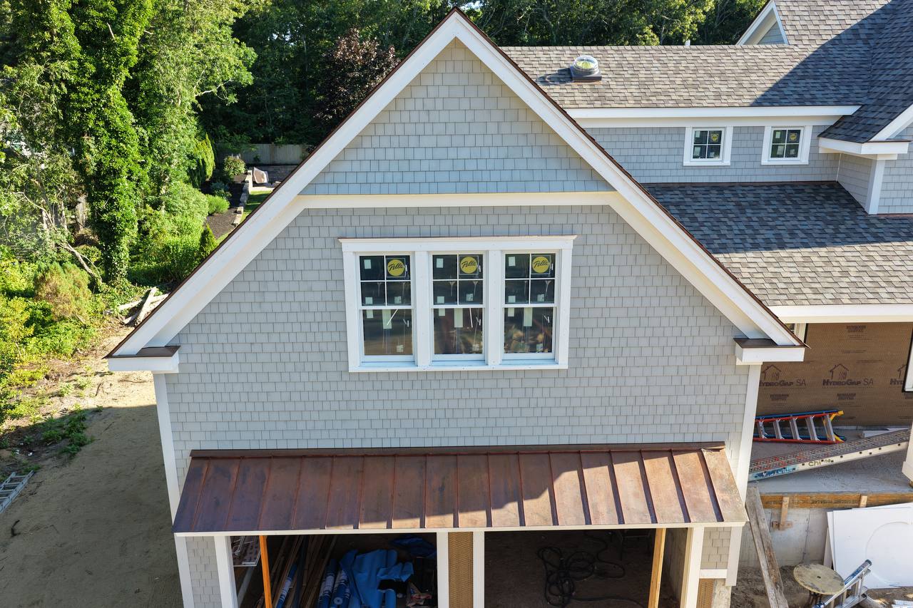 Close-up of painted cedar shingle coursing and white trim