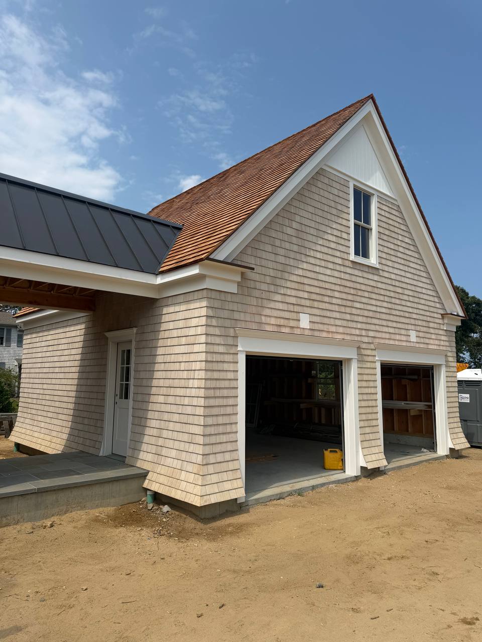 Dark standing seam metal roof over the breezeway connecting the structures