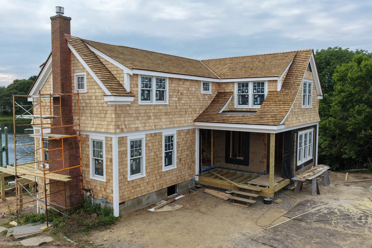 White cedar sidewall installation around black framed windows